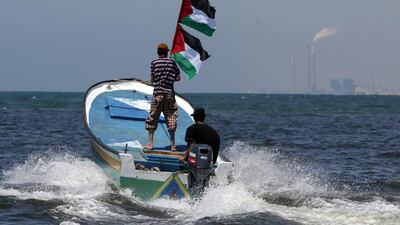 Palestinians wave their national flag during a rally near Gaza City on June 28, 2015, in support of a flotilla that attempted to defy Israel’s blockade of Gaza. Mahmud Hams / AFP