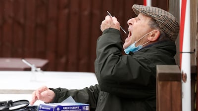 A man swabs the back of his throat at a mobile testing site at the Bramley Inn in the village of Bramley, west of London. AFP