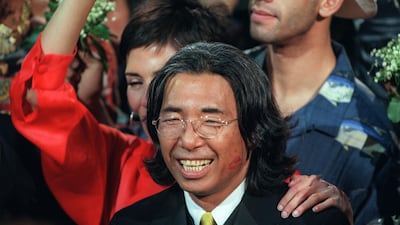 Fashion designer Kenzo Takada acknowledges the audience after showing his final Kenzo collection on October 7, 1999. AFP