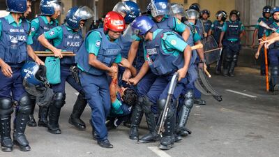 Police carry a wounded police officer during a clash between police, pro-government supporters and protesters, after anti-quota protesters demanded the resignation of Ms Hasina in the Karwan Bazar area, in Dhaka, Bangladesh. Getty Images