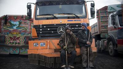 Afghan workers hold shovels as they wait to load coal.