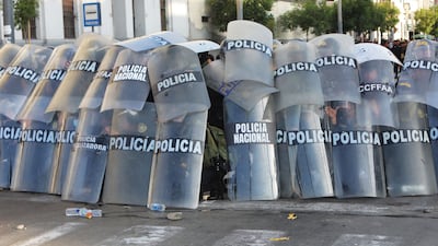 Police take cover during a demonstration against the government of Peruvian President Dina Boluarte in Lima. AFP