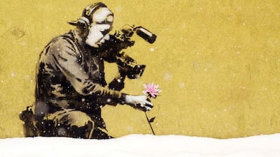 Two Utah paintings by the mysterious British graffiti artist Banksy were the targets of vandalism on New Year’s Eve, possibly ruining one of the works in the town that hosts the Sundance Film Festival. Brown spray paint Thursday covered a Park City mural that depicted a young boy with a pink halo and angel wings kneeling to pray behind a can of pink paint. The clear protective covering over the image had been shattered. The second piece, of a cameraman stooped to shoot video footage of a flower, was not defaced, but the covering had been cracked. NO CREDIT