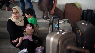 A Palestinian woman holds her daughter as they wait for a travel permit to cross into Egypt through the Rafah border crossing after it was opened by Egyptian authorities for humanitarian cases, in Rafah in the southern Gaza Strip August 16, 2017. Ibraheem Abu Mustafa / Reuters