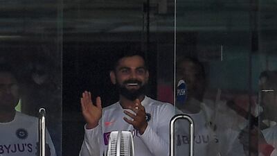 India captain Virat Kohli applauds in the dressing room after teammate Umesh Yadav hits a six. AFP