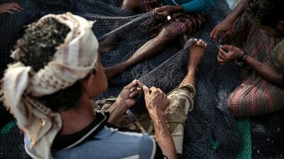 In this Sept. 29, 2018, photo, fishermen fix their nets before a fishing trip at the main fishing port, in Hodeida, Yemen. (AP Photo/Hani Mohammed)