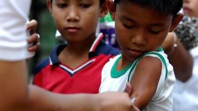 A Filipino nurse giving a boy his measles vaccine in a slum area in Tondo, Manila.