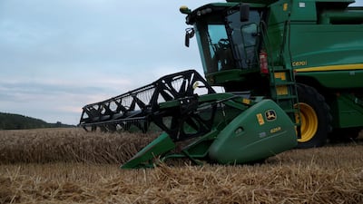 A combine harvests wheat in a field in the UK. UK farmers who managed to store grain over the winter months are securing high prices for grain they sell now, but challenges remain. Reuters