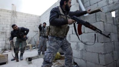 Free Syrian army fighters take cover on a roof near Al Neirab airport in Aleppo on Sunday. Hamid Khatib / Reuters
