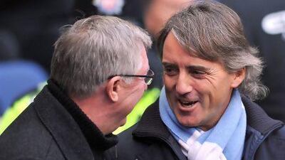 Roberto Mancini, right, the Manchester City manager, praised Sir Alex Ferguson, left, for the mentality at Manchester United, but says his side will be better than their city and title rivals. Paul Ellis / AFP
