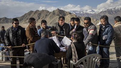 Election workers check voting machines before leaving a central collection point for polling stations.