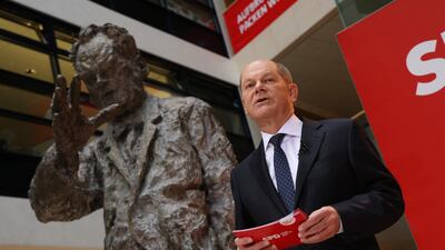 German Chancellor Olaf Scholz gives a speech next to a statue of Cold War leader Willy Brandt, whose peacemaking efforts shaped the outlook of much of Mr Scholz's generation. Getty Images
