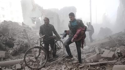 A Syrian man carries a wounded child following reported government airstrikes on the rebel-held town of Douma. Sameer Al Doumy / AFP Photo / February 25, 2017