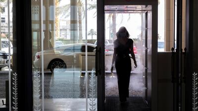 A woman walks through the disinfection booth at the Palazzo Versace hotel, Dubai. Chris Whiteoak / The National