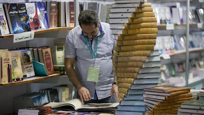 A man glances at a book at the fair.