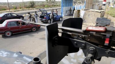 Iraqi federal policemen search a car at a checkpoint in Baghdad on Saturday. Karim Kadim / AP Photo