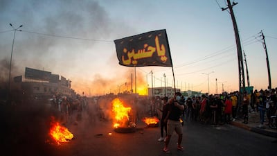Iraqi demonstrators gather near burning tyres during a protest near the governor's residence in the southern city of Basra. AFP