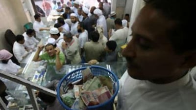A Man holds baskets filled with foreign currencies to take it to the 1st floor of a money exchanging store as Muslim pilgrims exchange different currencies to Saudi riyal in Mecca.