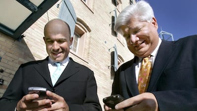 In this 2006 photo, Jim Balsillie, left, then the RIM co-chief executive, and Mike Lazaridis, the company’s founder use their BlackBerry devices. JP Moczulski / Reuters