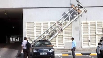 The building maintenance cradle came crashing down and fell over a car outside Millennium Plaza Hotel on Sheikh Zayed Road in Dubai yesterday afternoon. No one was injured. Jaime Puebla / The National