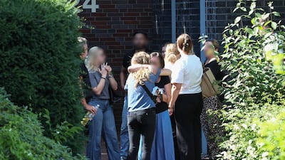 Employees at the youth welfare centre and witnesses comfort each other after the shooting spree. AFP