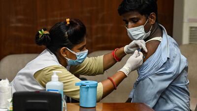 A health worker inoculates a man with a booster dose.