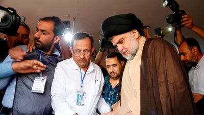 Iraqi Shiite cleric and leader Moqtada al-Sadr puts his ballot through an electronic counting machine into a ballot box at poll station in Najaf on May 12, 2018. Some Iraqis have raised concerns that the machines could be hacked. Haidar Hamdani / AFP