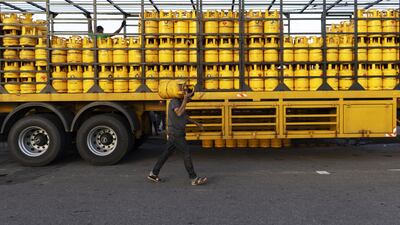 A man carries a cooking gas cylinder in Galle, Sri Lanka. The country has decided to limit distribution of fuel to essential services until July 10. Bloomberg