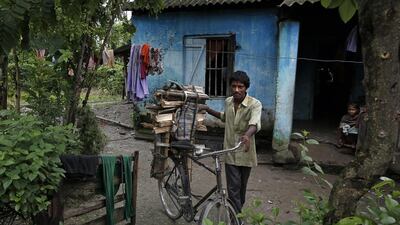 Tea worker Prashuram Mahali leaves for a local market to sell wood from his house in Bundapani.