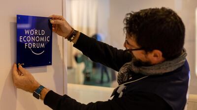 A worker hangs a sign inside the Congress Centre ahead of the World Economic Forum in Davos, Switzerland. Bloomberg