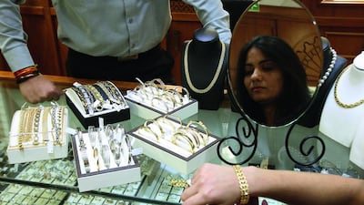 A customer tries on gold jewellery at the Cara Jewellers in Gold and Diamond Park in Dubai. Pawan Singh / The National