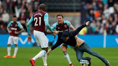 West Ham United's Mark Noble clashes with a fan who has invaded the pitch. Peter Cziborra / Reuters
