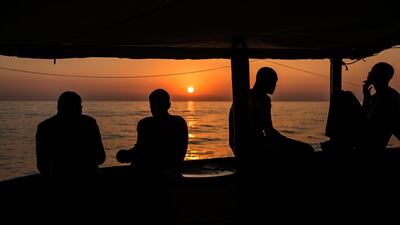 Migrants talk aboard the Open Arms aid boat, of Proactiva Open Arms Spanish NGO, talk as the ship approaches the port of Barcelona, Spain, Wednesday, July 4, 2018. AP