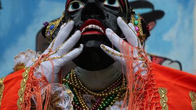 Luis Chacon, the current person representing Mama Negra, adjusts his mask during the festival in honor of the Virgin of Las Mercedes in Latacunga, Ecuador. AP Photo