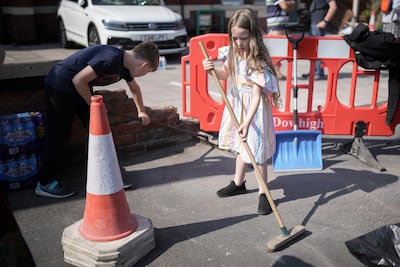 Children sweep up outside a mosque that was attacked in Southport, UK. Getty Images