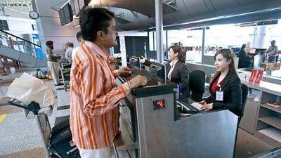 A customer service agent helps a passenger from New Delhi check in at Sharjah International Airport. Jeff Topping / The National