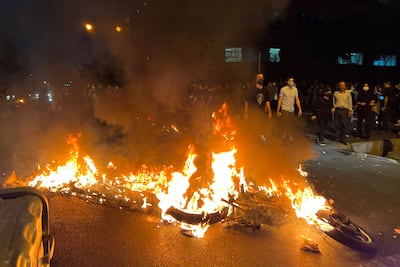 Demonstrators gather round a burning motorbike during a protest over the death of Mahsa Amini. AFP
