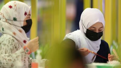 Schoolchildren wearing face masks take part in a workshop. EPA