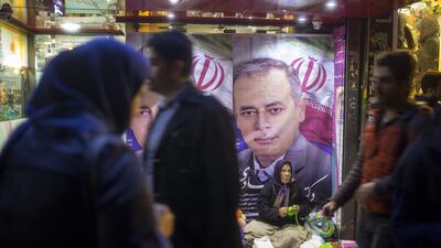 People in tehran walk past campaign posters for Iran’s parliamentary election held on February 26, 2016. Majid Saeedi / Getty Images