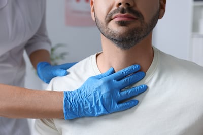 An endocrinologist examines the thyroid gland of a patient at hospital. Getty Images