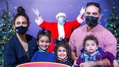 The Nachar family pose with socially distanced Santa at the Winter Village, The Galleria Al Maryah Island. Victor Besa / The National