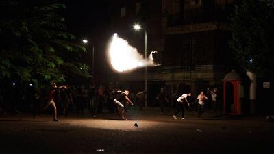 A protestor throws a petrol bomb at Egyptian riot police guarding the Syrian embassy during a demonstration in Cairo. Dozens of anti-Syrian President Bashar al Assad demonstrators clashed with Egyptian police outside the Syrian embassy. Gianluigi Guercia / AFP Photo