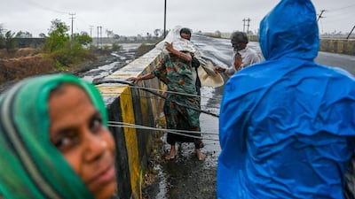 Villagers and a fallen electricity cable on a bridge near Diu, south-western India. AFP