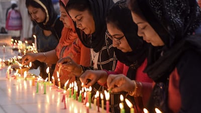 Sikh devotees light candles to pay respect on the occasion of Bandi Chhor Divas, a Sikh festival coinciding with Diwali, the Hindu festival of light, at the Golden Temple in Amritsar on November 14, 2020. / AFP / NARINDER NANU