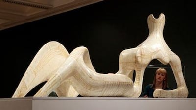 A woman admires Henry Moore's Reclining Figure 1951 on display at the Tate Britain.