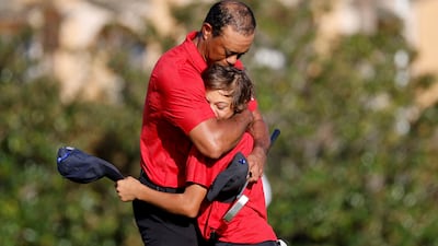 Tiger Woods embraces his son Charlie on the 18th green. Reuters