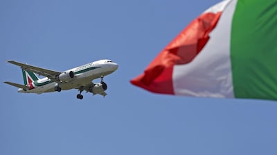 An Italy flag flutters as an Alitalia airplane approaches to land at Fiumicino airport in Rome July 31, 2014. Italy's loss-making flag carrier Alitalia is working on a final proposal to present to Etihad on Thursday in a push to lock in an investment by the Abu Dhabi-based airline, a person close to Alitalia shareholders said on Wednesday. Etihad's plans to take a 49 percent stake in Alitalia, which has made a profit only a few times in its 68-year history, has been held up by disagreements over Alitalia's 800 million euro ($1.07 billion) debt pile, and plans for job cuts that have stoked outrage among Italian unions. REUTERS/Max Rossi (ITALY - Tags: TRANSPORT BUSINESS EMPLOYMENT)