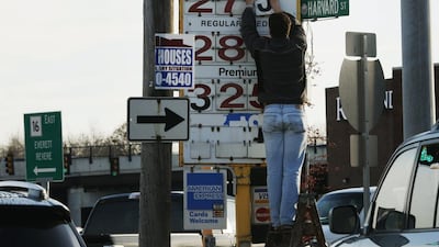 A man changes the price for a gallon of gasoline at a gas station in Medford, Massachusetts, on December 4. Brent crude oil fell below US$69 a barrel on Thursday after Saudi Arabia announced deep cuts in selling prices for Asian and US buyers, a week after refusing to support OPEC output cuts. Brian Snyder / Reuters