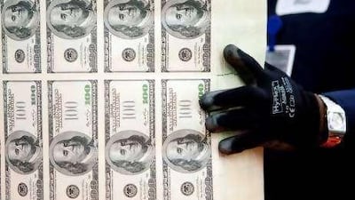 A vibrating table loosens a stack of $100 bills at the Bureau of Engraving and Printing in Washington.