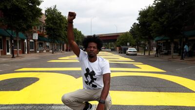 Ricco Wright poses for a photo on a street painted with a 'Black Lives Matter' message to mark Juneteenth. Reuters